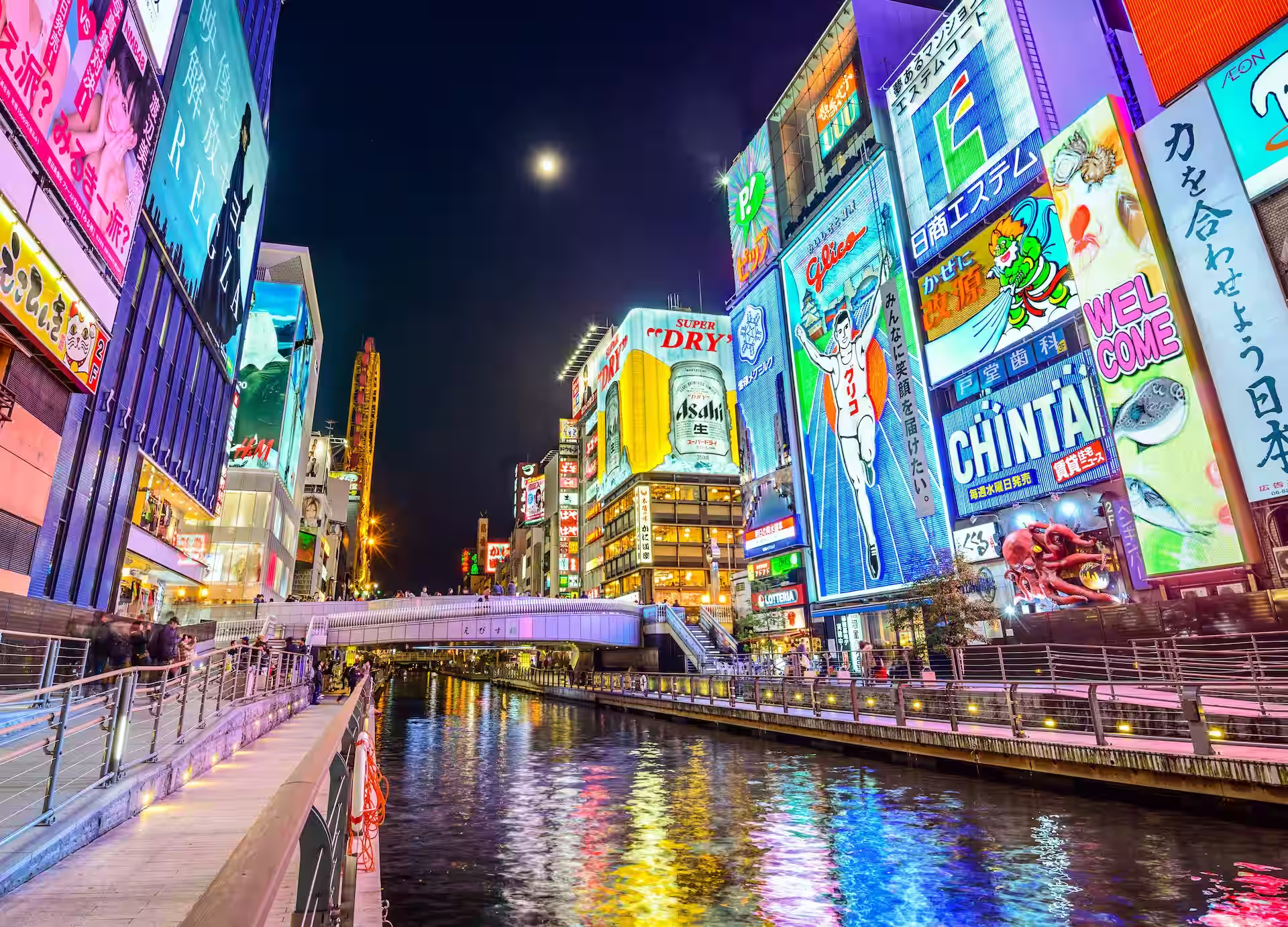 Canal de Dotonbori y letreros iluminados al atardecer en Osaka.